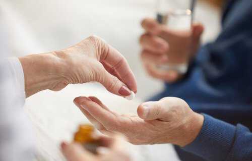 Doctor handing medication to patient